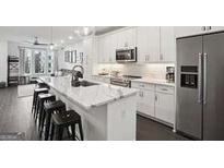 Open kitchen featuring a large island with white countertop and stainless steel appliances at 1050 Stacks Ave # 1507, Atlanta, GA 30315
