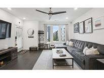 Bright living room features dark wood floors, ceiling fan, and large couch with lots of sunlight at 1050 Stacks Ave # 1507, Atlanta, GA 30315