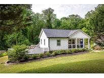 Charming home with a landscaped front yard, classic white siding, and a welcoming blue front door at 1711 Terry Mill Se Rd, Atlanta, GA 30316