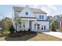 Charming two-story home with white siding, brick accents, well-manicured lawn, and inviting covered porch at 602 Belshire Dr, Acworth, GA 30102