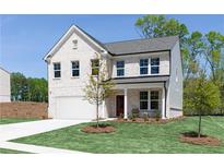 Charming two-story home boasts a white brick facade, attached garage, and neatly manicured lawn at 608 Belshire Dr, Acworth, GA 30102