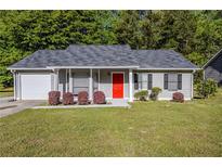 Charming home with a well-manicured lawn and a bright red front door adding a pop of color at 6895 Brown S Dr, Fairburn, GA 30213