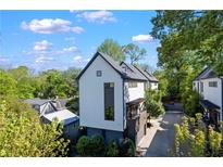 Striking modern home with white siding, dark trim, lush landscaping, and private driveway on a sunny day at 1331 Iverson Ne St # A, Atlanta, GA 30307