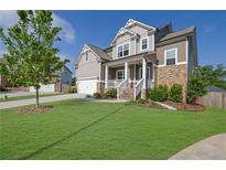 Charming two-story home featuring a well-manicured lawn and inviting front porch at 5985 Hidden Ridge Ct, Cumming, GA 30028