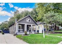 Charming home with a landscaped front yard, featuring a covered porch with elegant columns and ample parking at 1463 Metropolitan Sw Pkwy, Atlanta, GA 30310