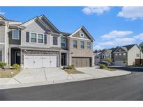 Beautiful townhome with a two-car garage and charming brick and siding exterior at 7676 Viking Rd, Fairburn, GA 30213