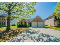 Charming brick home with a two-car garage and a well-maintained front yard and driveway at 1401 Kala Dr, Lithonia, GA 30058