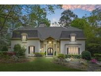 Stately home with manicured lawn, lush landscaping, and charming architectural details at 315 Mossy Pointe, Duluth, GA 30097