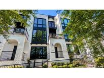 Modern townhome with sleek black windows and a charming wrought-iron balcony, surrounded by lush greenery at 1268 Appleden Way # 17, Brookhaven, GA 30319