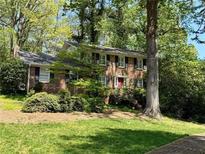 Charming two-story brick home with lush landscaping and a classic red front door at 2603 Kings Lake Ne Ct, Atlanta, GA 30345