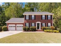 Traditional two-story brick home with a manicured front lawn and attached two car garage at 850 Madison Chase Way, Lawrenceville, GA 30045