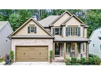 Charming two-story home with brick and siding exterior, two-car garage, covered porch, and professionally landscaped front yard at 117 Manous Dr, Canton, GA 30115