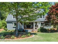 Charming gray brick home with a welcoming front porch and mature landscaping in a peaceful setting at 4220 Fairgreen Dr, Marietta, GA 30068