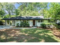 Charming brick home with a well-manicured lawn, covered car port, and inviting curb appeal at 3200 Rehoboth Dr, Decatur, GA 30033