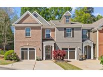 Charming townhome with brick and gray siding, attached garages, and well-maintained landscaping at 5260 Sherwood Way, Cumming, GA 30040