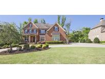 Spacious front yard with a large lawn and a beautifully landscaped garden leading up to the brick home at 2331 Kinsale Nw Pt, Kennesaw, GA 30152