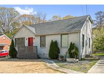 Charming painted brick home with a gray shingled roof, red front door, and manicured landscaping at 1952 Don Juan Ln, Decatur, GA 30032