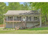 Charming two-story home featuring a cozy front porch, wood railings, and a well-maintained landscaped yard at 1206 Parkwood Chase, Acworth, GA 30102