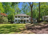 Charming two-story home with a landscaped yard and a classic white facade, surrounded by mature trees at 4505 Glengary Ne Dr, Atlanta, GA 30342