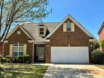 Beautiful brick home with well-manicured lawn and a spacious two-car garage on a sunny day at 8531 Spivey Village Trl, Jonesboro, GA 30236