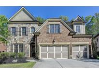 Charming brick and stone home with a three-car garage and manicured front yard at 3330 Camellia Ln, Suwanee, GA 30024