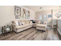 Spacious living room features a large sectional sofa, hardwood floors, and stylish wall art at 1137 Liberty Nw Pkwy, Atlanta, GA 30318