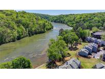 Scenic aerial view of community nestled beside the Chattahoochee River surrounded by lush greenery and trees at 1119 Riverbend Club Se Dr, Atlanta, GA 30339