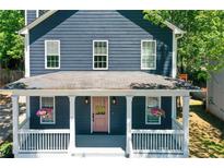 Charming home featuring a covered porch, pink front door, and navy blue siding at 22 Haygood Se Ave, Atlanta, GA 30315