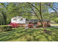 Charming two-story home with well-maintained lawn and colorful flowering bushes enhancing its curb appeal at 1649 Clairmont Ne Way, Brookhaven, GA 30329