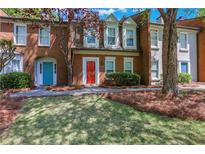Charming brick townhome with colorful doors and well-maintained landscaping at 4128 Boxwood Way, Duluth, GA 30096
