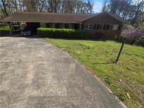 Cozy one-story brick home featuring well-maintained landscaping and a convenient carport at 2790 Hogan, East Point, GA 30344