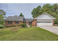 Charming brick ranch home with a well-maintained front yard and attached garage at 1766 Scholar Dr, Lawrenceville, GA 30044
