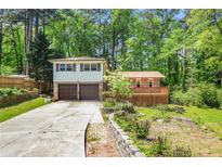 Charming home featuring a two-car garage and a spacious deck, nestled among mature trees at 2645 Davenport Rd, Duluth, GA 30096