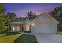Charming single-story home with well-manicured lawn and attached two-car garage at dusk at 2505 Rockmart Rd, Villa Rica, GA 30180