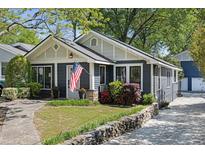 Charming single-story home featuring a well-manicured front yard with an American flag and stone accents at 1195 Oglethorpe Ne Ave, Atlanta, GA 30319