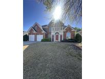 Charming two-story brick home with a two-car garage, balcony, and well-manicured lawn at 1410 White Flowers Ln, Lawrenceville, GA 30045