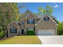 Charming two-story brick home featuring a well-manicured lawn and attached two car garage at 3338 Hackmatack Nw Dr, Kennesaw, GA 30152