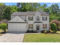Charming two-story home with a two-car garage, landscaped front yard, and fresh, white exterior at 4680 Glen Level Dr, Sugar Hill, GA 30518