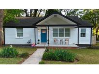 Charming home with a quaint front porch, painted white brick, and a bright blue front door at 2447 Hillside Ave, Decatur, GA 30032