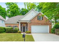 Charming brick home featuring manicured lawn, two-car garage, and lush landscaping at 2918 Arbor Creek Ln, Atlanta, GA 30340