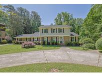 Charming two-story home boasts a well-manicured lawn and a long driveway, surrounded by lush trees at 3563 Castleridge Dr, Tucker, GA 30084