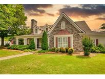 Charming stone and siding home with well-manicured lawn and mature landscaping at 3818 Bay Forest Way, Loganville, GA 30052