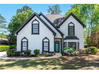 Charming two-story home featuring a well-manicured lawn and beautiful landscaping around the front of the house at 4161 Sherwood Oaks Dr, Decatur, GA 30034