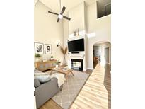 Bright living room with ceiling fan, fireplace, large screen TV, and wood flooring at 164 Haven Oak Way, Lawrenceville, GA 30044