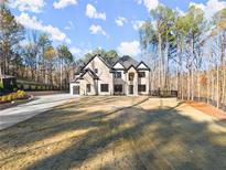 Stunning two-story home boasting stone and brick accents, a modern garage door, and a meticulously designed landscape at 1540 Brooks S Rd, Lawrenceville, GA 30045