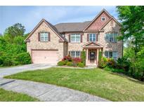 Charming two-story brick home featuring a well-manicured lawn, attached garage, and mature landscaping at 1993 Side Branch Way, Lawrenceville, GA 30045