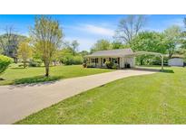 Charming single-story home with a long driveway and covered parking on a large lot with mature trees at 63 Seminole Ne Rd, Cartersville, GA 30121