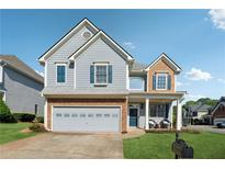 Charming two-story home with a brick-accented garage and well-manicured lawn at 400 Mirramont Ln, Woodstock, GA 30189