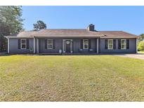 Charming single-story home with a well-manicured lawn and cozy front porch seating at 95 Graystone Dr, Covington, GA 30014