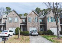 Charming townhouse with stone and brick facade, attached garages, and well-maintained landscaping at 275 Fern Crest Dr, Lawrenceville, GA 30046
